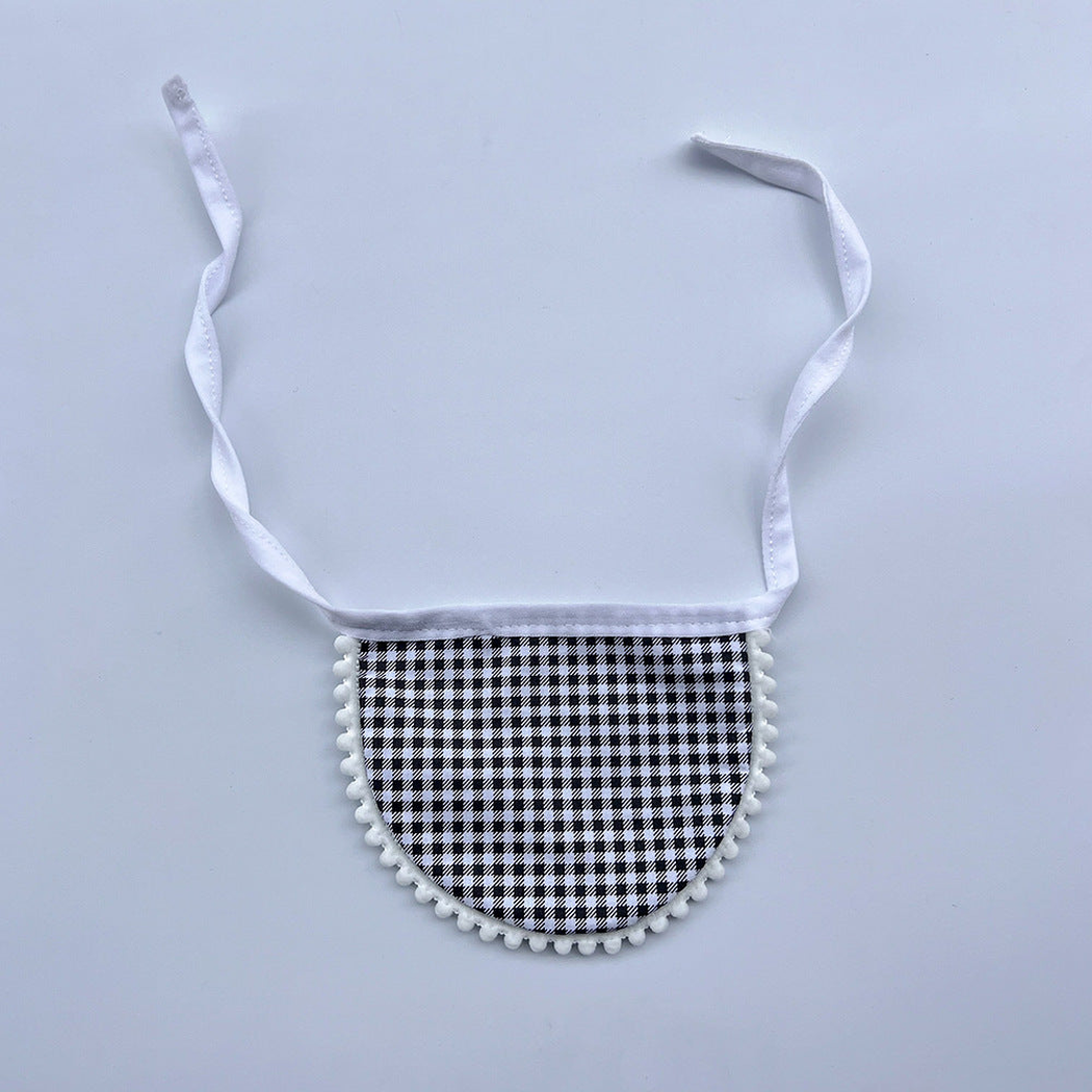 Black gingham Pet Neckwear with white neck ties and pom-pom edging, laid flat.