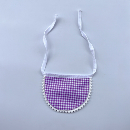 Purple gingham Pet Neckwear with white neck ties and pom-pom edging, laid flat.