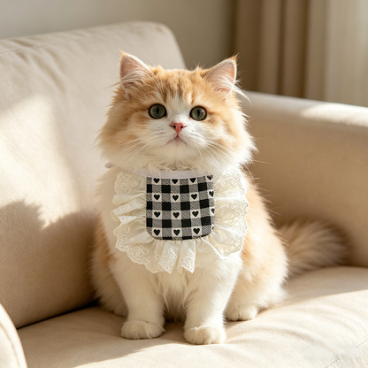 Orange-and-white cat wearing Square heart-check Pet Neckwear with white ruffled lace-look trim on a cream sofa.