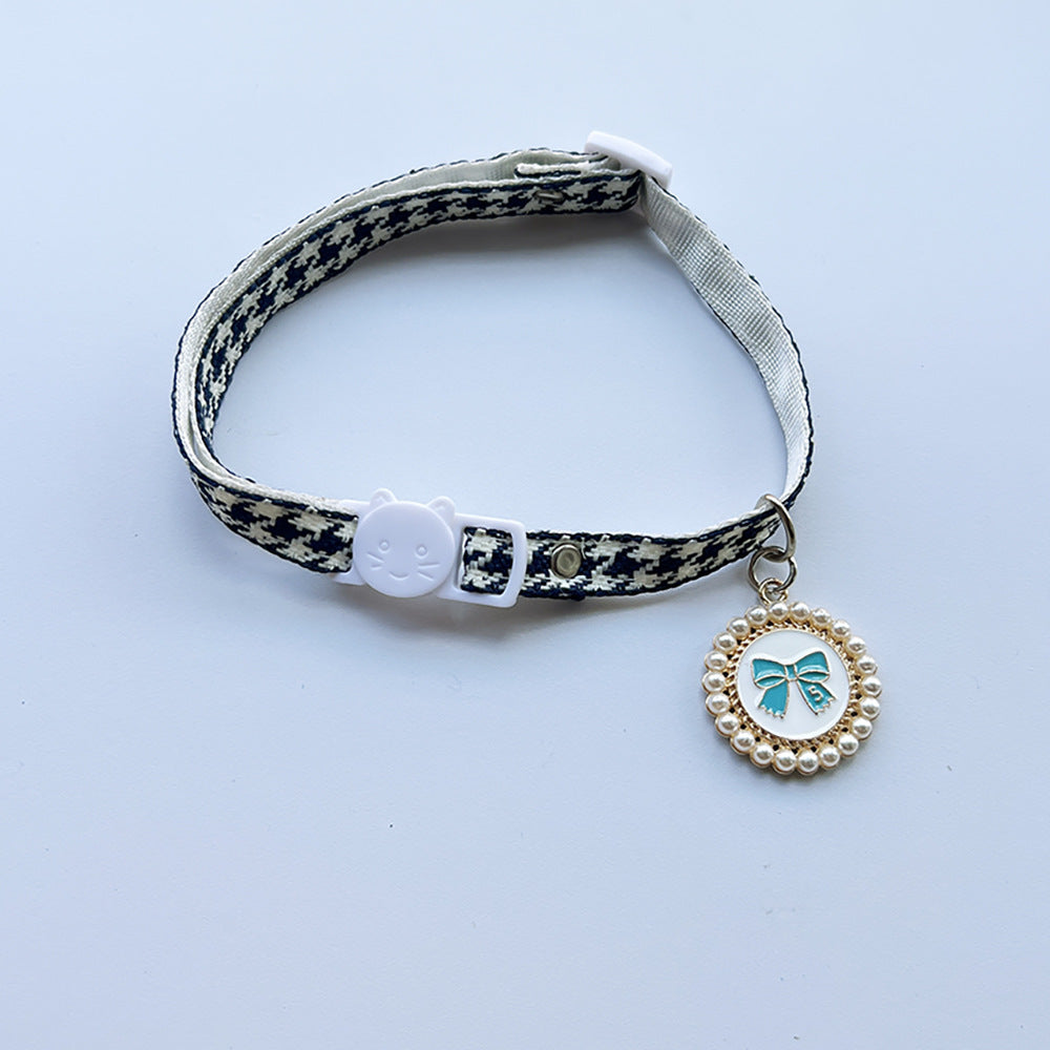 Navy houndstooth cat collar with cat-face buckle and blue bow charm