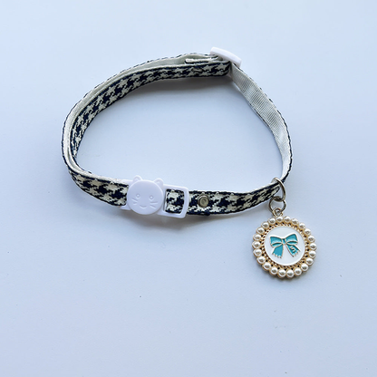 Navy houndstooth cat collar with cat-face buckle and blue bow charm