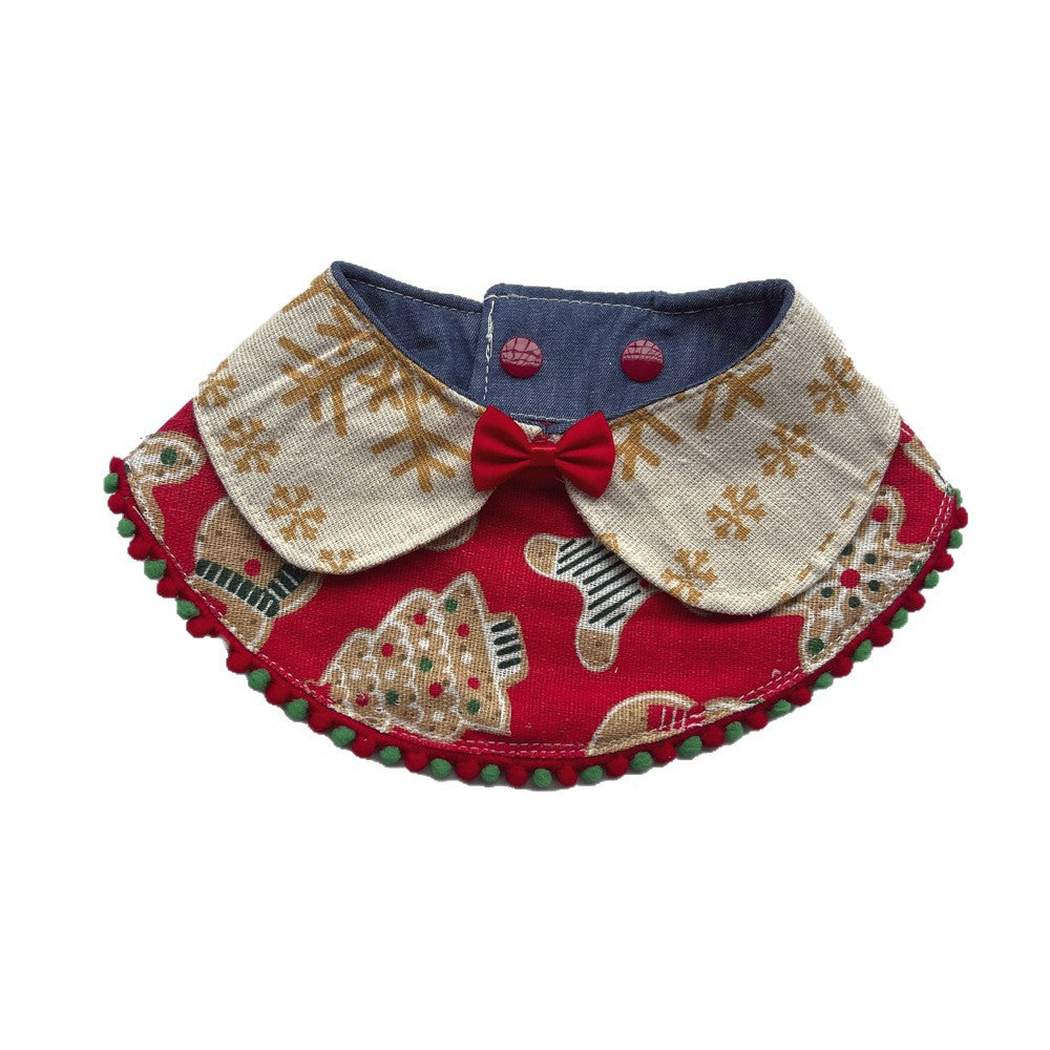 Red Bib pet neckwear with ivory snowflake lapels, a red bow, and red and green pom-pom trim.