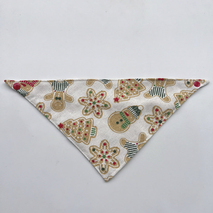 Ivory Bandana pet neckwear laid flat, with gingerbread figures, snowmen, trees, and red corner snaps.