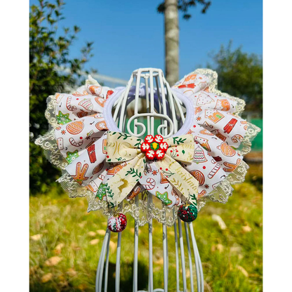 Cream / Red Pet Neckwear on a display stand outdoors, with printed ruffles, a cream bow, lace-look edging and dangling ornaments.