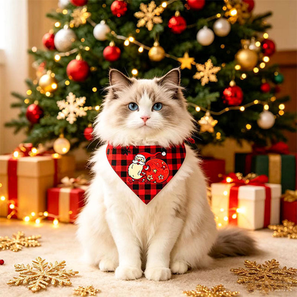 Cat wearing red and black checked pet neckwear with a Santa motif beside a decorated Christmas tree.