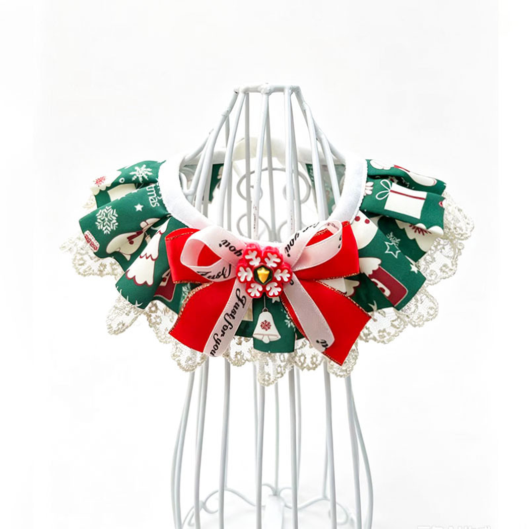 Green pet neckwear with tree and gift motifs, lace-look edging and a red and pale ribbon bow.