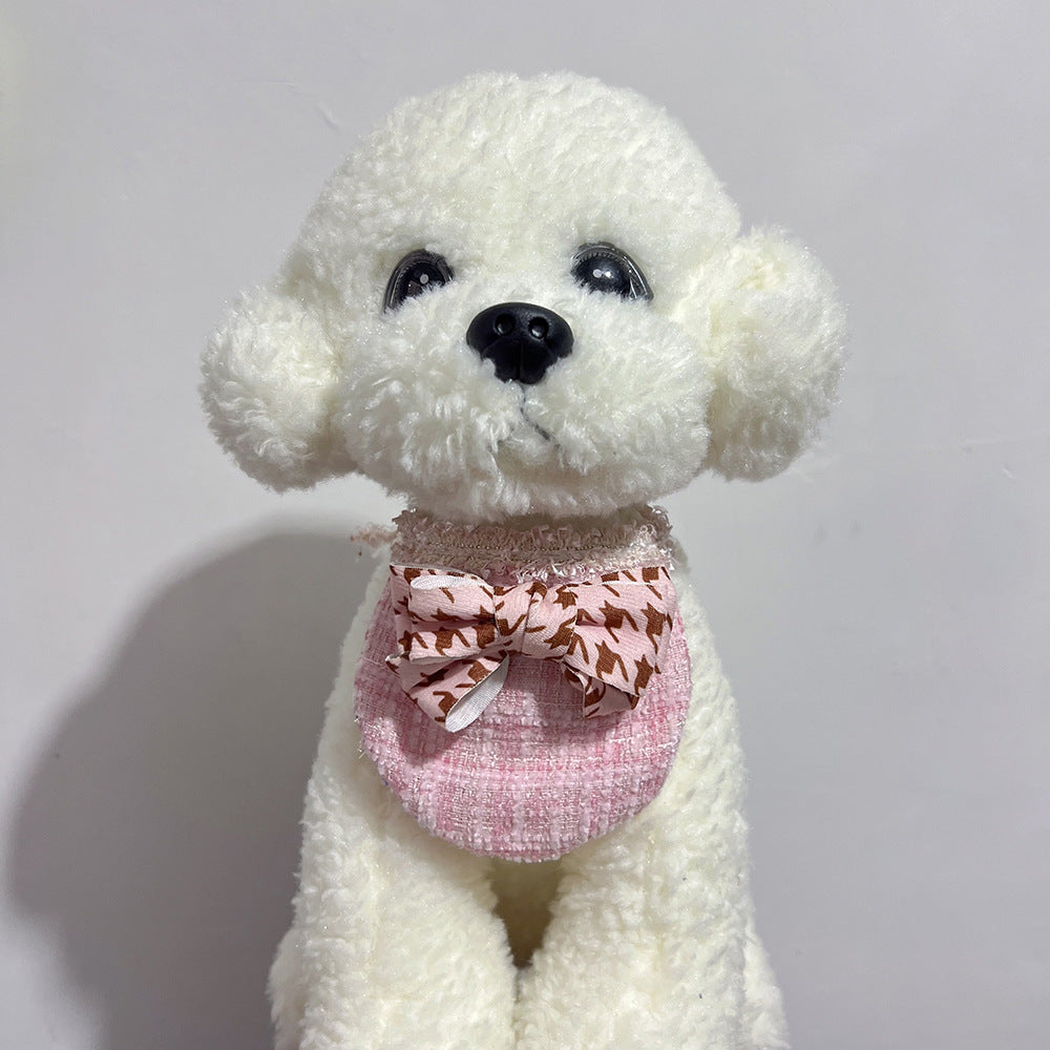 White plush dog wearing Pink Check Pet Neckwear with a patterned bow, front view.