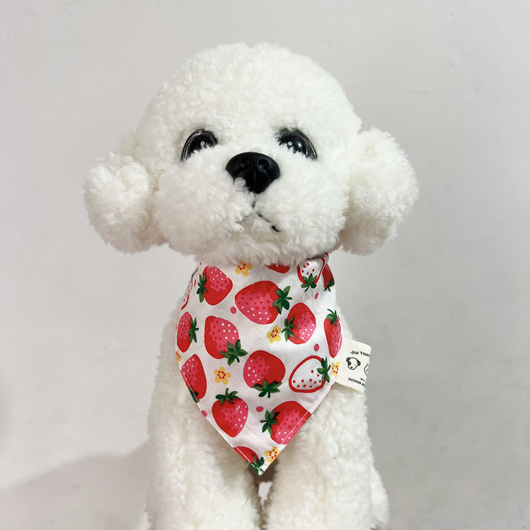 White plush dog wearing Red Bandana Pet Neckwear with a strawberry pattern and pointed front.