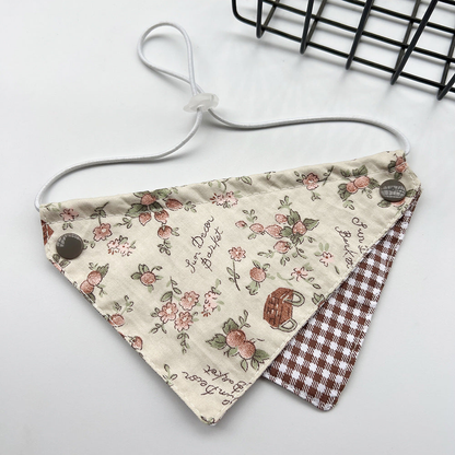 Brown Bib Pet Neckwear with floral and basket motifs, a brown gingham lower panel and a white cord loop.