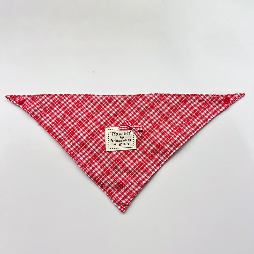Red Bandana pet neckwear spread flat with white checks, corner snaps and a small bow beside a square label.