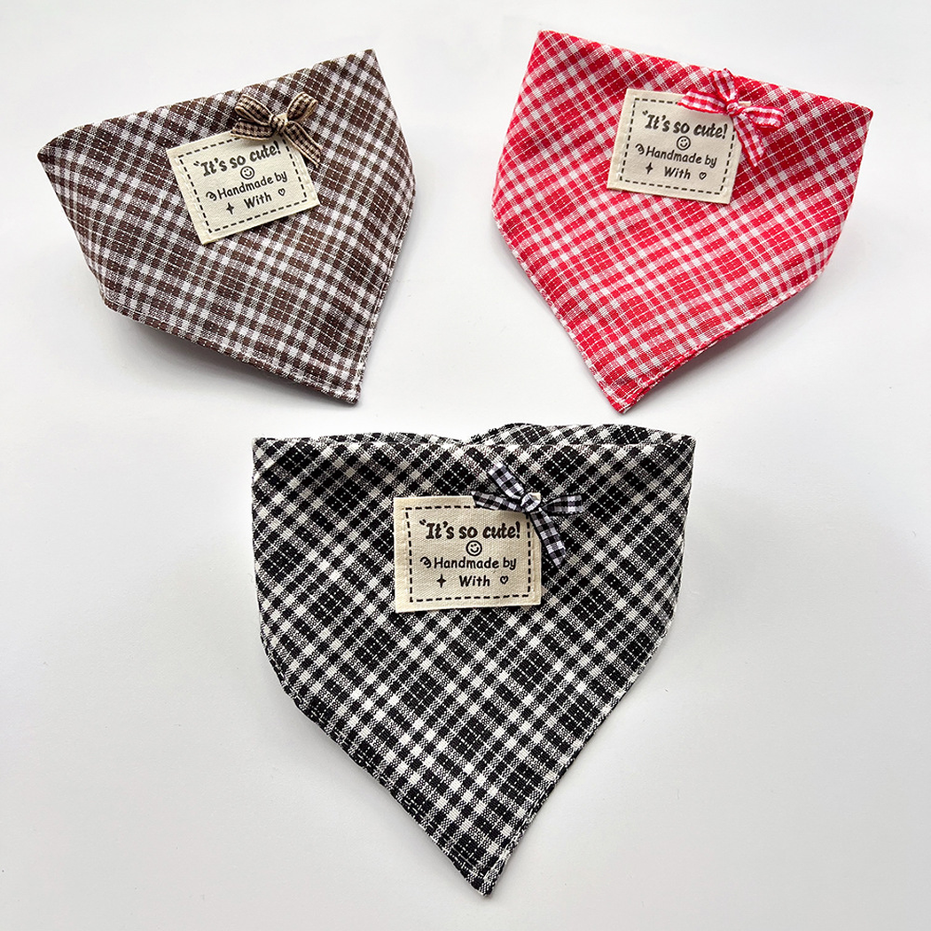 Brown, red and black checked bandana-style pet neckwear in curved shapes with small bows and square labels.