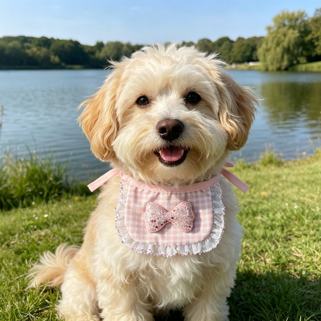 Dog wearing Pink Sparkle Pet Neckwear with a glittery bow and ruffled border beside a lake.