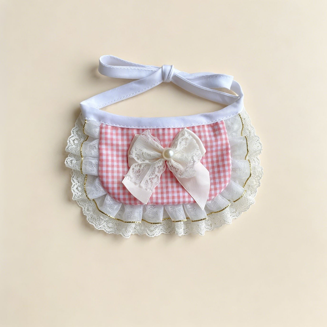 Pink gingham pet neckwear with a layered white bow, scalloped lace-look edging, and white tie straps.