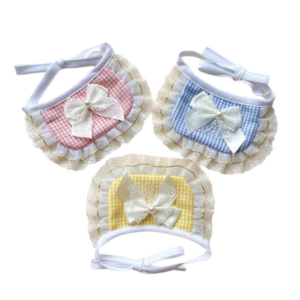 Pink, blue, and yellow gingham pet neckwear with white bows and ruffled edging displayed together.