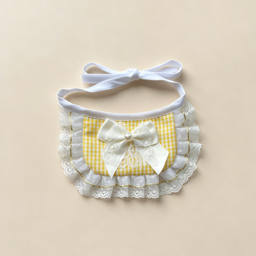 Yellow gingham pet neckwear with a white bow, layered ruffles, and white tie straps.