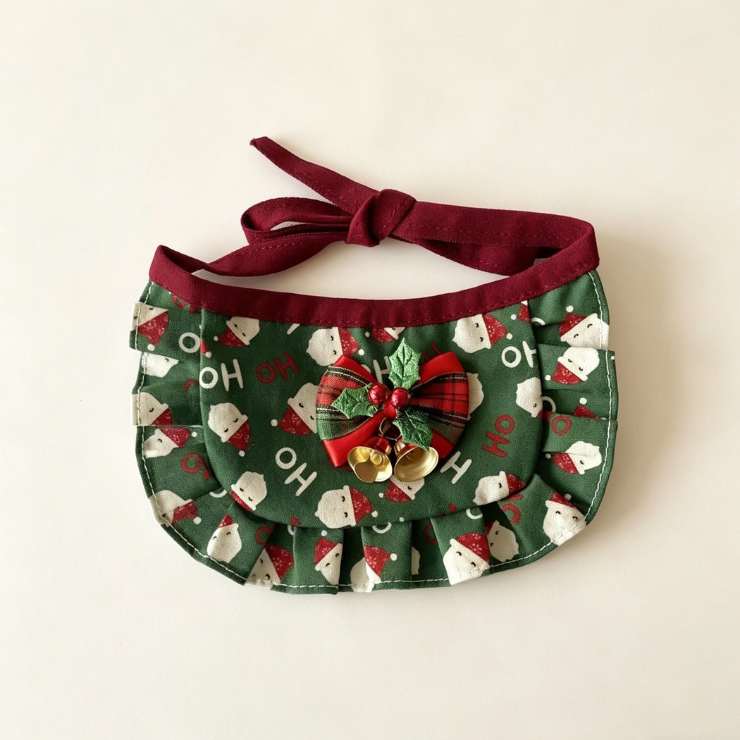 Santa Bib Pet Neckwear with green Santa print, ruffled border, holly-decorated bow and two gold-tone bells.