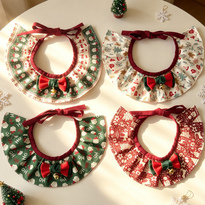 Four ruffled Pet Neckwear styles with patterned prints, burgundy ties, red and green bows and gold-tone bells on a decorated tabletop.