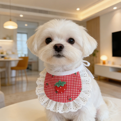 White dog wearing rounded strawberry gingham pet neckwear with white eyelet ruffles.