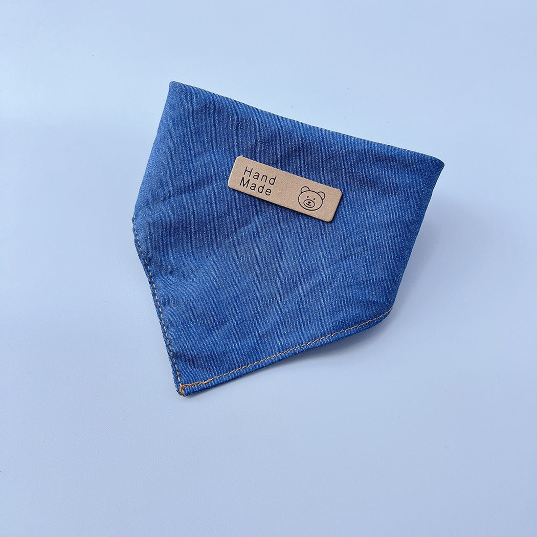 Blue pet neckwear folded into a pointed bib shape with contrasting edge stitching.