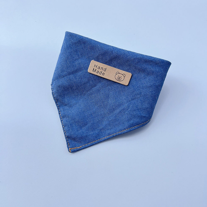 Blue pet neckwear folded into a pointed bib shape with contrasting edge stitching.