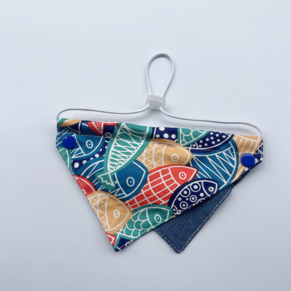 Multicolor Bib pet neckwear with overlapping fish motifs, blue snaps and a white cord loop