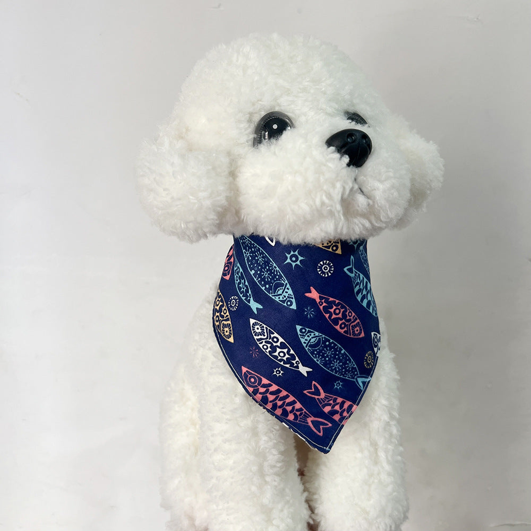 White plush dog wearing Navy Bandana pet neckwear with colorful fish motifs