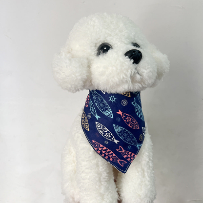 White plush dog wearing Navy Bandana pet neckwear with colorful fish motifs