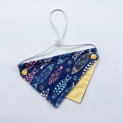 Navy Bib pet neckwear with colorful fish motifs, yellow inner panel and white cord loop
