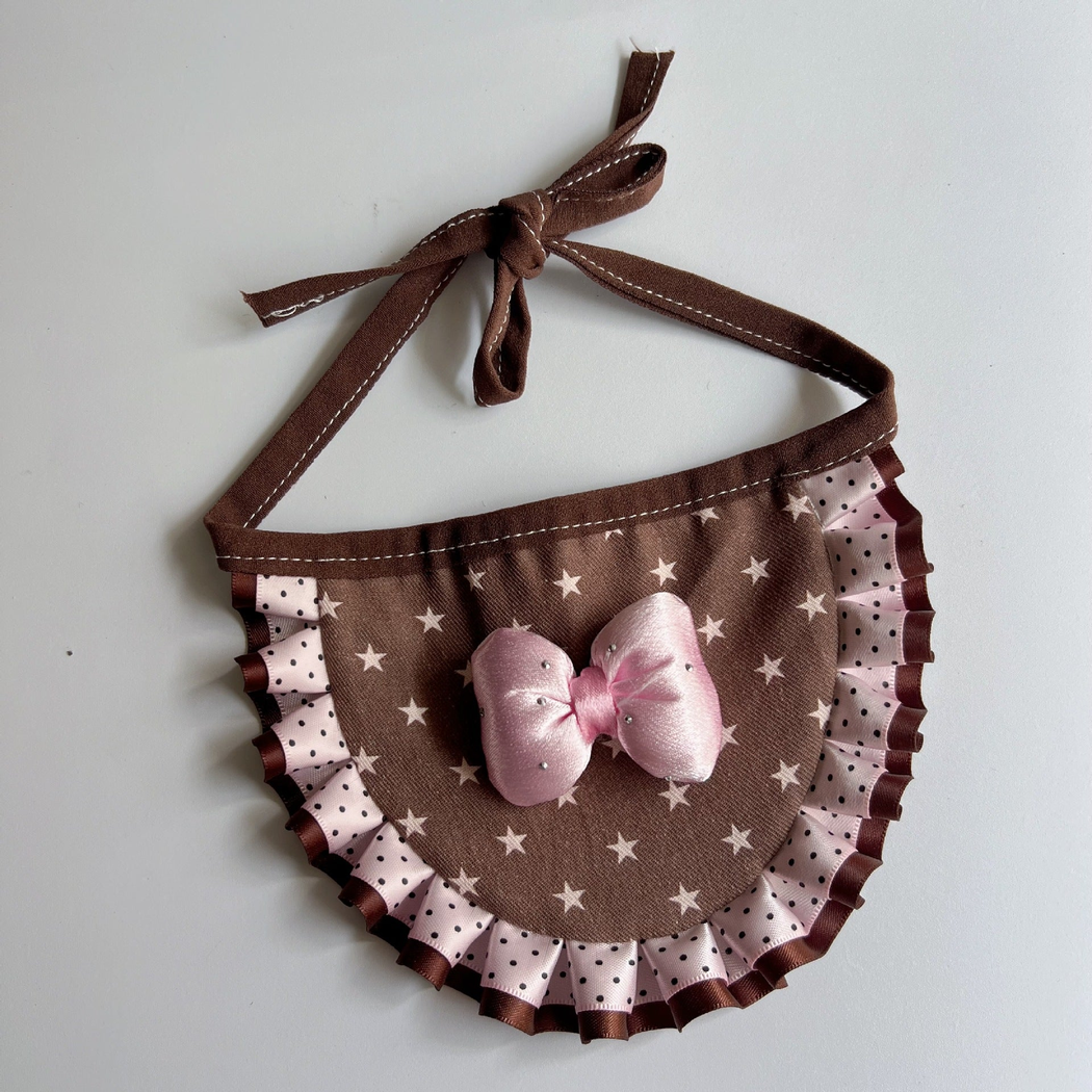 Pink pet neckwear with a brown star-print panel, pink bow, polka-dot ruffle, and tied brown straps