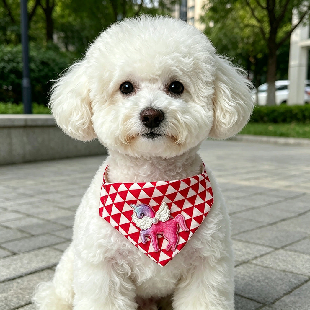White dog wearing red-and-white Bandana pet neckwear with a pink winged unicorn accent outdoors, close view.