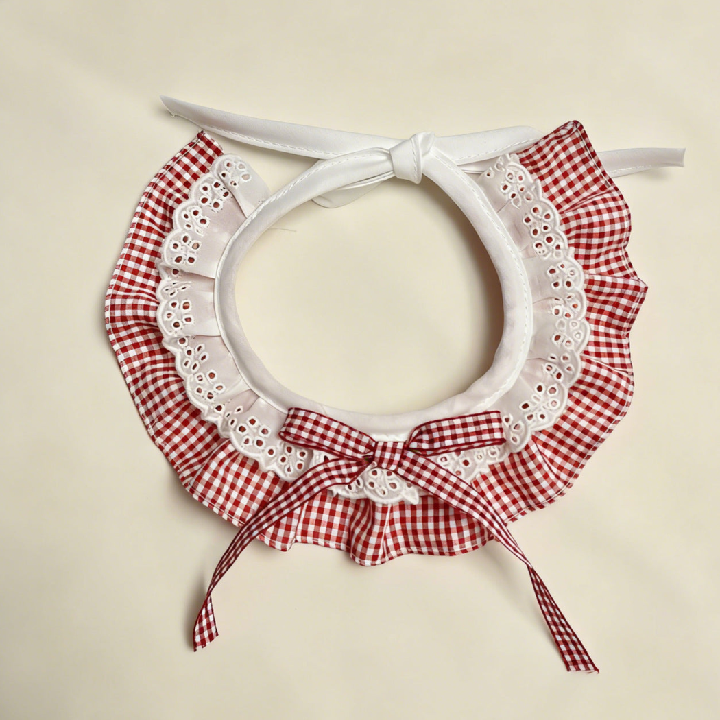 Red gingham Pet Neckwear with white lace-look ruffles, matching bow, and white ties.