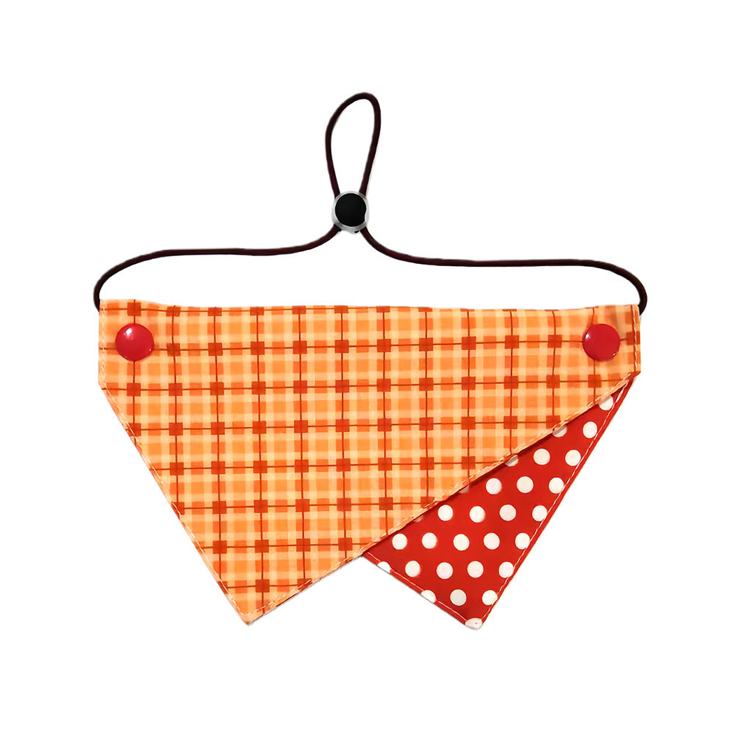 Plaid pet neckwear with an orange triangular panel and red reverse with white dots
