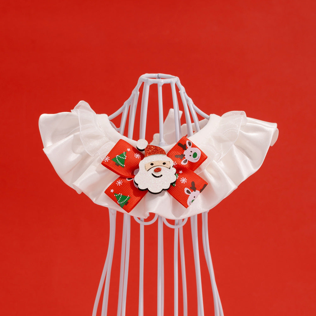 Santa pet neckwear draped on a white display form, showing layered ruffles and a red bow.
