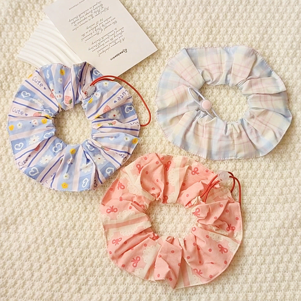 Bow, Floral, and Plaid ruffled Pet Neckwear arranged together on a cream background.