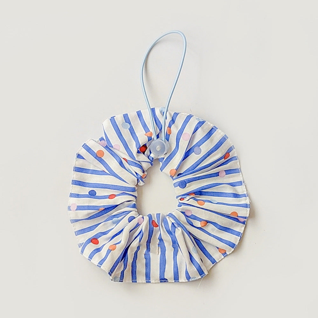 Blue ruffled pet neckwear with white stripes, multicolored dots, and a pale blue loop with round adjuster.