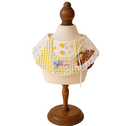 Yellow gingham and pastel star pet neckwear on a display stand, with bows, lace-look trim, and a flower basket appliqué.