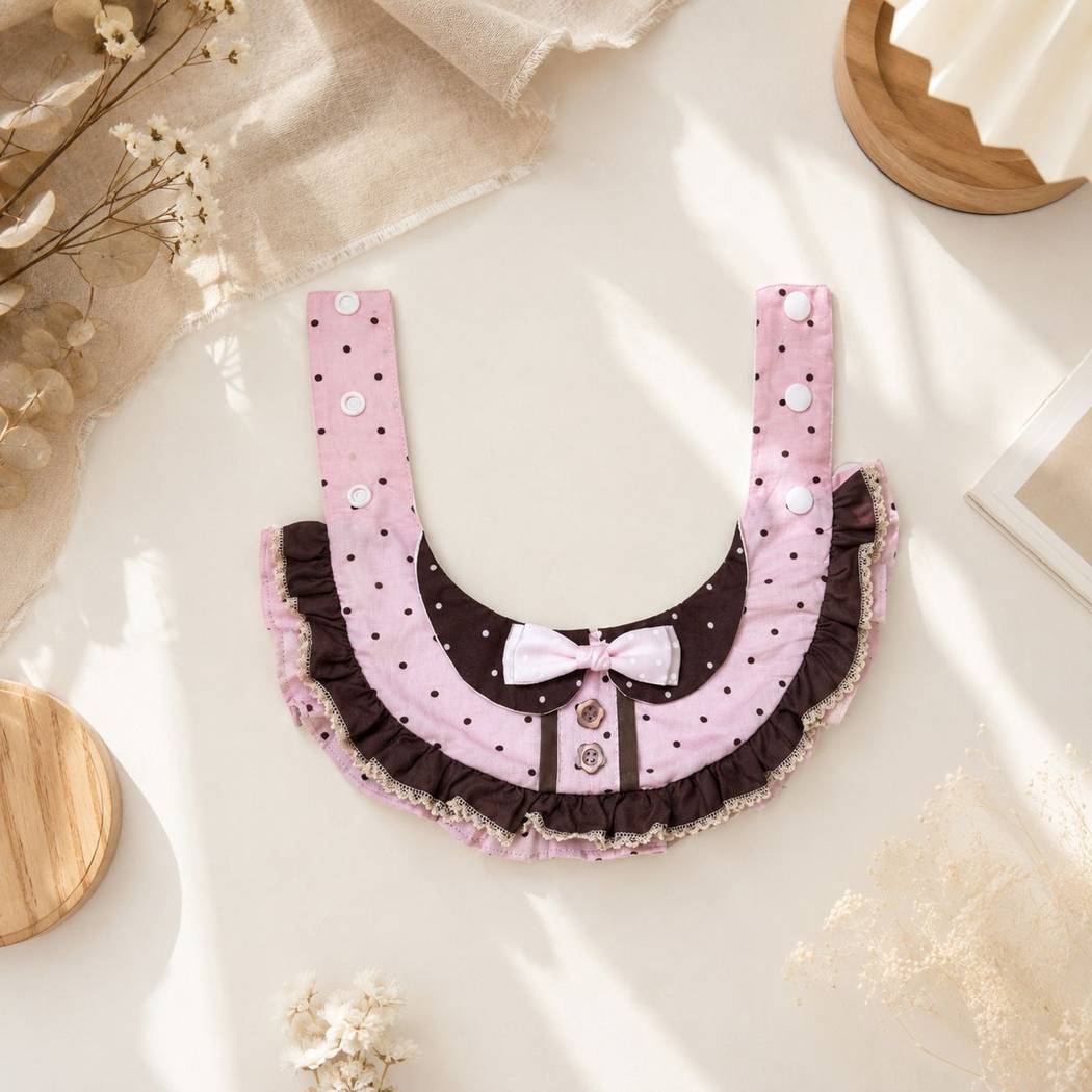 Pink and brown pet neckwear laid open to show neck straps, snap fasteners, and lace-look ruffled edging.