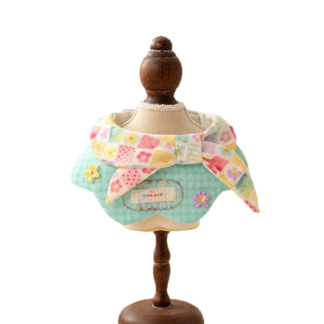 Mint plaid pet neckwear with a pastel floral bow and flower accents displayed on a mannequin against white.