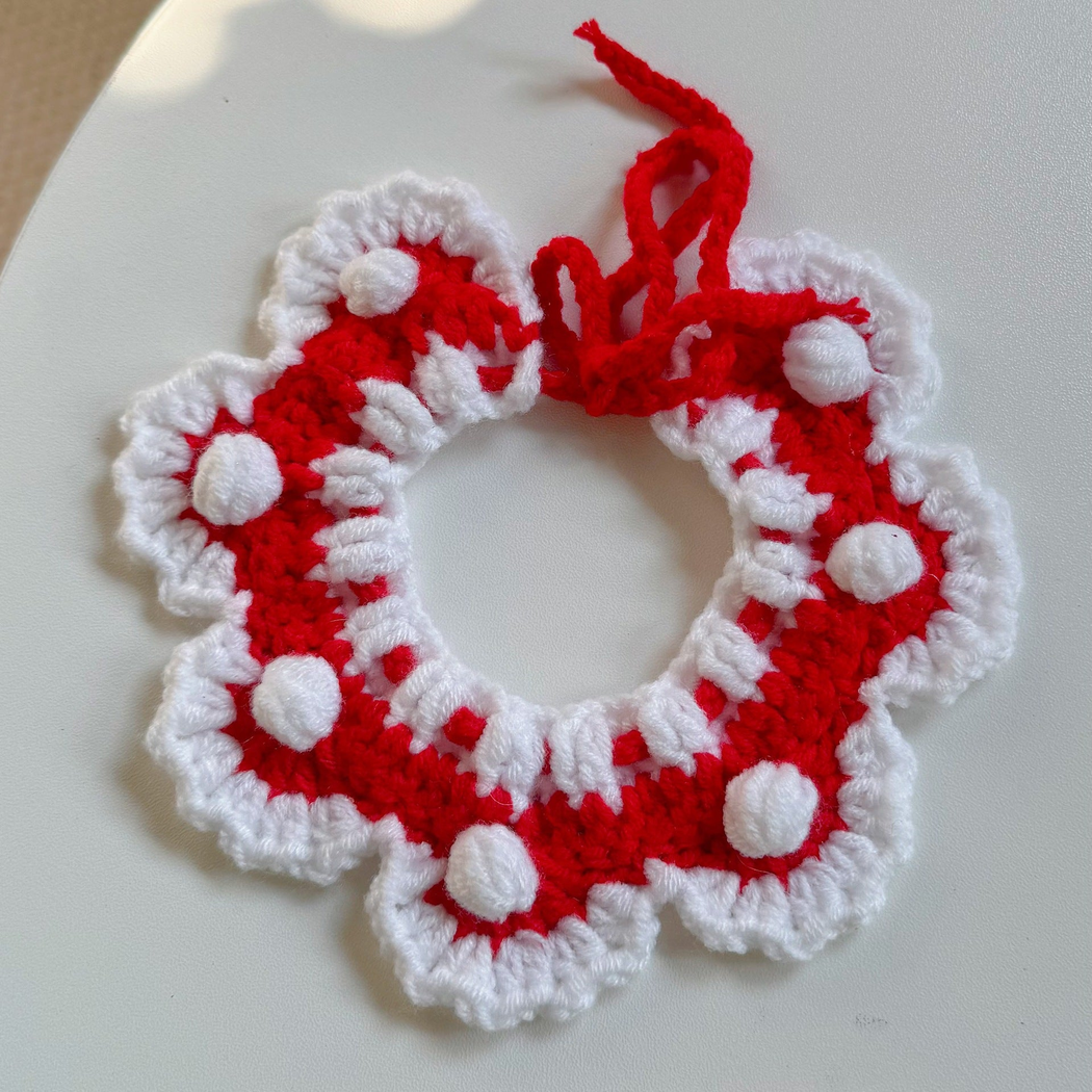 Red and white pet neckwear with scalloped edging, tie strings, and raised round accents