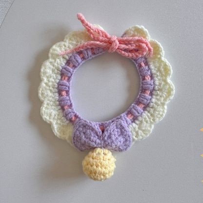 Purple Pink pet neckwear with a bow, ruffled edge, tie strings, and yellow pom-pom