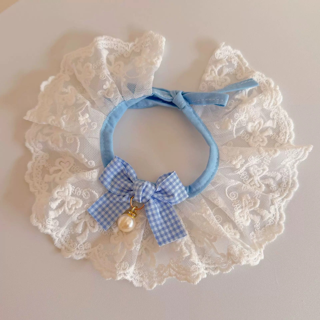 Light Blue and white ruffled pet neckwear with a checkered bow, laid flat