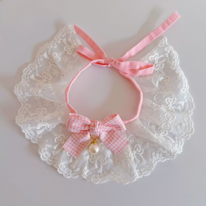 Pink and white pet neckwear with floral lace-look ruffles, a checkered bow, and pearl-look ornament
