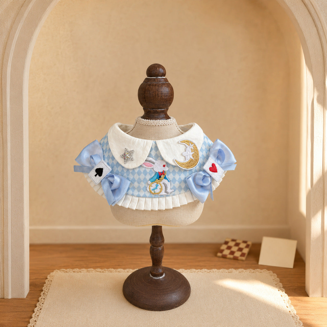 Blue-and-white patterned pet neckwear with bows displayed on a wooden stand in a warm room