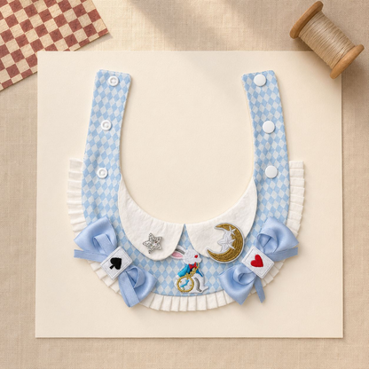 Flat detail view of blue-and-white pet neckwear with bows, pleated edge, and decorative motifs