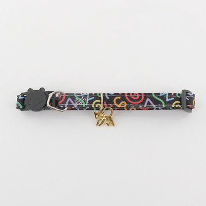 Close-up of black patterned pet neckwear with a gold-tone cat charm