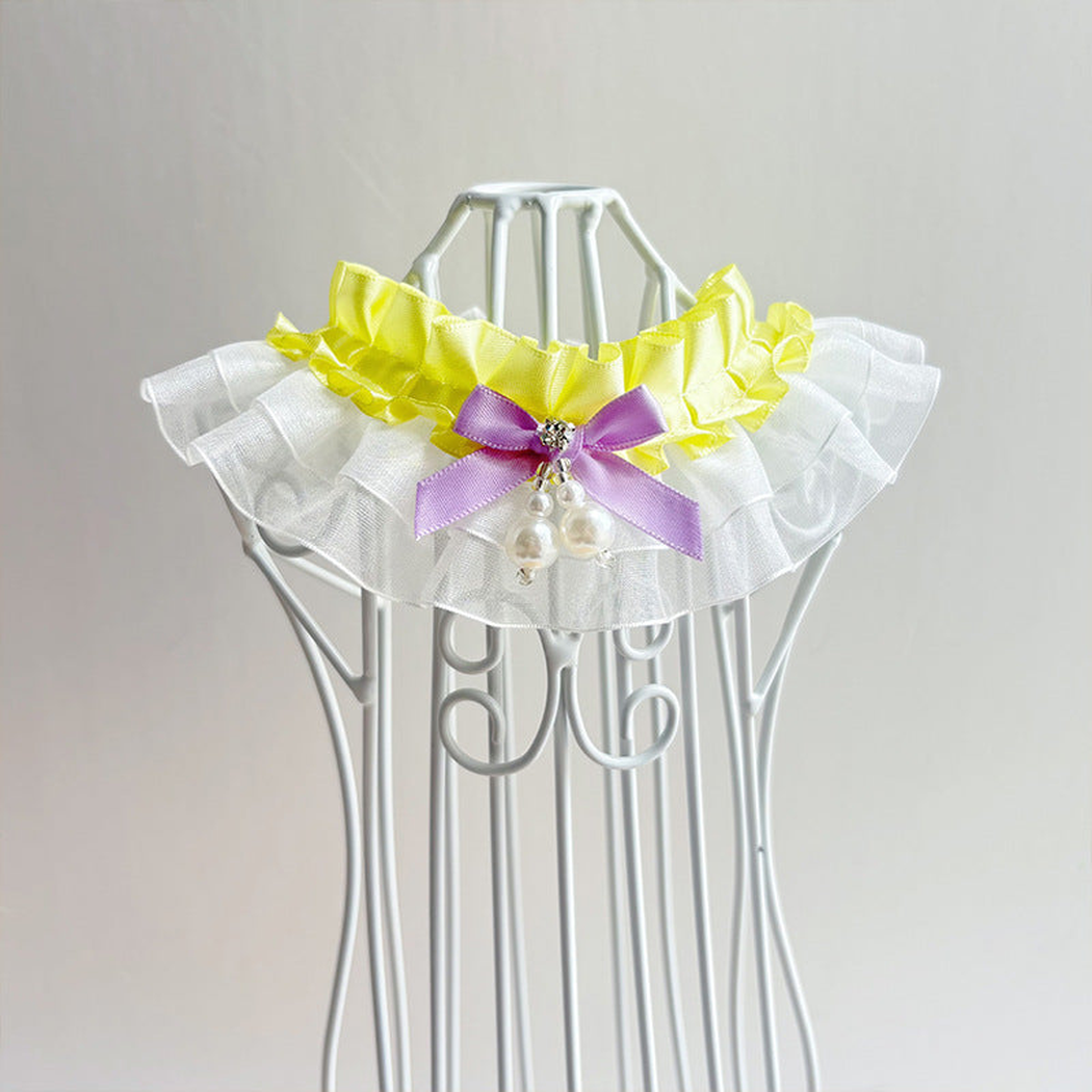 Yellow layered ruffled pet neckwear with a contrasting bow and dangling bead accents