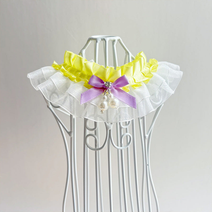 Yellow layered ruffled pet neckwear with a contrasting bow and dangling bead accents