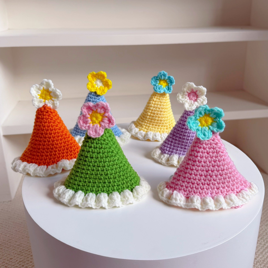 Nine colorful flower-trimmed pet hats displayed together
