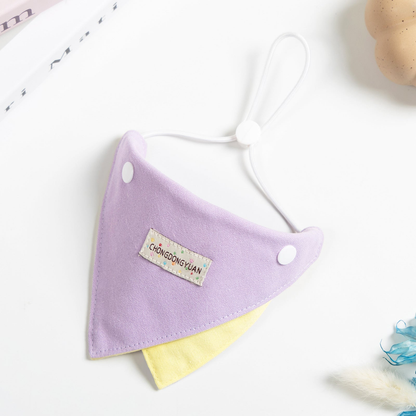 Purple triangular pet neckwear with a yellow contrasting panel, angled view