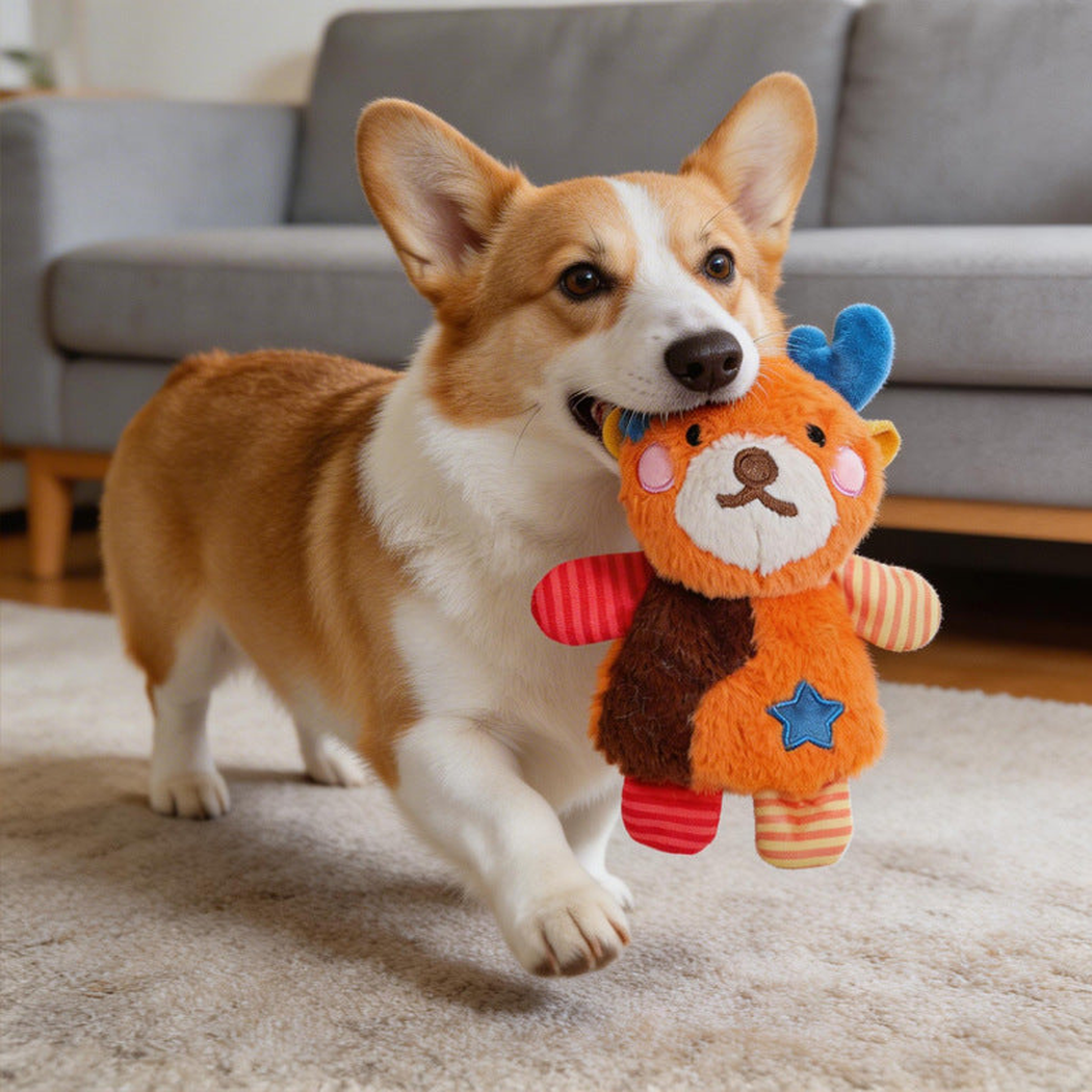 A dog holding an orange fox plush dog toy in its mouth
